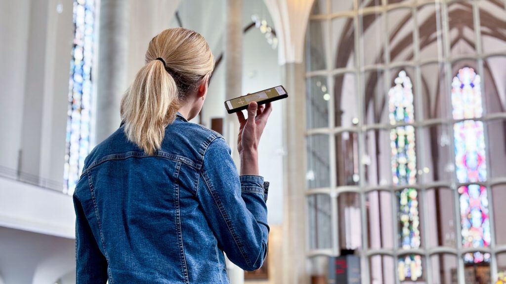 Besucherin nutzt den digitalen Audioguide in der Martinskirche Kassel